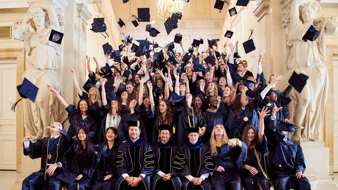 group photo students throwing caps in the air Webster University in Vienna commencement 2022